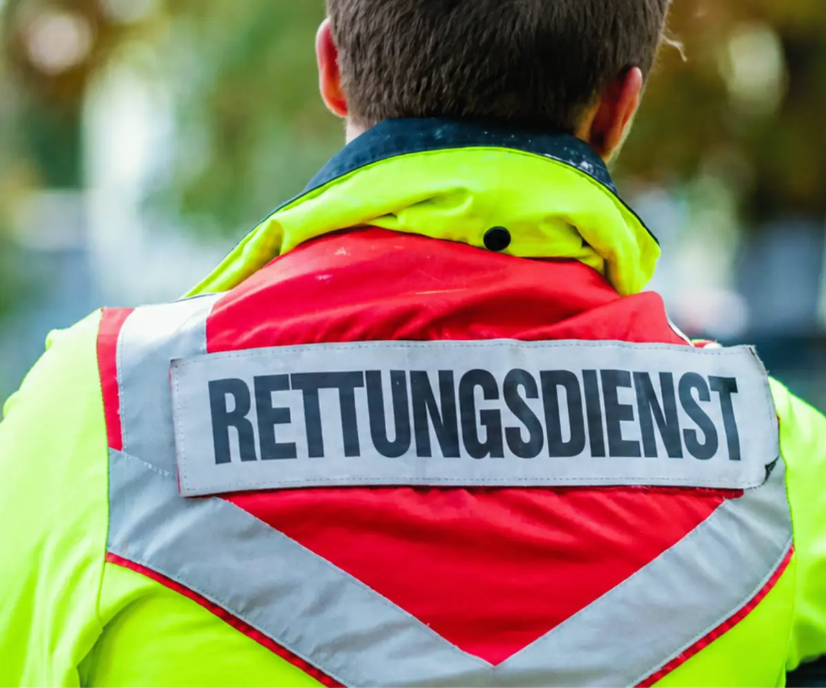 Rettungsdienstmitarbeiter von hinten mit der Aufschrift „Rettungsdienst“ auf der Einsatzjacke